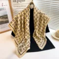 Close up detail view of a luxury style geometric monogram pattern silk scarf in elegant drape. - RY-14