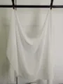 Gedetailleerd overzicht van een witte chiffon sjaal, lichtgewicht en ademende stof. - Ivoor