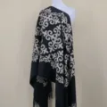 Close-up detail view of the embroidered ethnic pattern on the black cashmere scarf. - Black