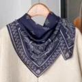 Detailed shot of a dark blue paisley cotton linen square scarf hanging on a wooden hanger. - RY-17