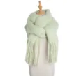 Close-up detail of soft fuzzy winter scarf knit texture green warm cozy apparel accessory. - Light Green