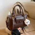Brown leather top-handle handbag with shoulder strap, cute fluffy charm and front pocket. - With Pendant / Coffee