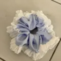 Blue satin hair scrunchie featuring elegant white lace ruffle trim detail close up. - Blue