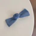 Detailed shot of the blue denim bow hair clip featuring a cute rose design for sweet styling. - Blue Bow Hair Clip
