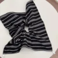 Detailed close-up view of the black and white striped fabric scrunchie with pearl. - Striped Scrunchie / Black