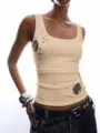 Detailed view of a stylish ribbed tank top with metallic grommets and cutout rings for summer. - Champagne
