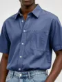 Close-up view of mens washed cotton short sleeve shirt showing chest pocket and buttons. - S / Green