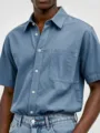 Close-up view of mens casual cotton short sleeve shirt showing chest pocket and button details. - S / Pink