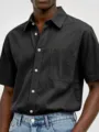 Close-up view of men's short sleeve casual shirt in washed cotton with chest pocket button detail - S / Black