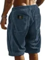 Men's corduroy shorts detail view showing back pocket, elastic waist and textured fabric. - S / Black