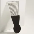 Detail shot of the metal afro pick comb with black handle, perfect for curly hair styling. - S1015-D