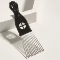 Detailed view of portable afro pick comb with fist handle and metal tines for curly hair styling. - C4