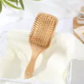 Natural bamboo cushion hair brush detail view, wooden massage pins for daily hair care routine. - L