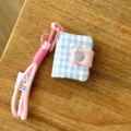 Niedlicher blauer Mini Fotoalbum Schlüsselanhänger mit rosa Band und Herz Knopf Anhänger. - Blau