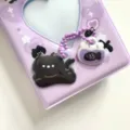 Primer plano del bonito archivador de photocards morado con dijes acrílicos de gato. - Colgante de Gato Negro