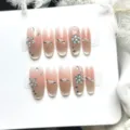 Faux ongles œil-de-chat faits à la main, rose nude glacé avec fleurs en strass bleus. - Très Petit (XS) / Ovale Moyen (W589)