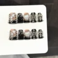 Closeup of gothic punk press-on nails featuring silver stars and rivets on black base. - Extra Small (XS) / Short Duckbill Style (K67)