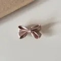 Satin bow hair clip detail shot, elegant pink color, soft fabric texture with metal clip. - Champagne Bow Hair Clip
