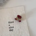 Gros plan détaillé d'une mini pince à cheveux rouge foncé avec décor en strass. - Pince crabe chien / Rouge