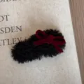 Nahaufnahme Detail einer süßen Herbst Winter Plüsch Haarklammer mit roter Samtschleife. - Schwarze Schleife Haarklammer