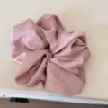 Detail shot of a pink satin scrunchie, soft and smooth texture for gentle hair styling. - Pink Hair Ring