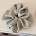 Detailed close-up of the smooth satin hair scrunchie texture, displaying elegant shine. - Light Green Scrunchie