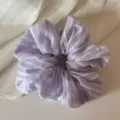 Gedetailleerd overzicht van de lila gestreepte haarscrunchie, zachte stoffen haaraccessoire. - Paars Gestreepte