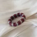 Detalle de coletero de punto, accesorio con patrón de cuadros rojo blanco y azul para peinados bonitos. - Lazo para el Cabello a Rayas Rojas