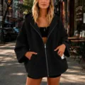 Close-up view of the casual black zip-up hoodie featuring 3/4 sleeves and cozy fit. - S / Black