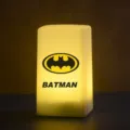 Vue détaillée de la veilleuse Batman, éclairant d'une douce lumière jaune dans l'obscurité. - Style 10