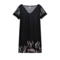 Détail de robe noire à col V, manches courtes en dentelle et impression sur l'ourlet. - Feuille