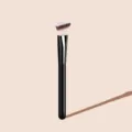Detail view of the angled makeup brush with soft bristles and sleek black handle. - Black