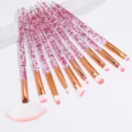 Detailed close-up view of glitter crystal makeup brushes set with fine synthetic hair. - 10 Piece Set / Red