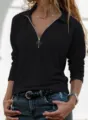 Close-up detail of women's black long sleeve polo zip-up top featuring metal ring zipper. - S / Black