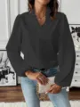 Close-up of elegant dark grey V-neck long sleeve blouse featuring delicate ruffles. - Black