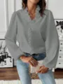 Close-up detail showcasing the elegant grey long sleeve ruffle V-neck shirt in interior room. - S / Gray