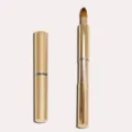 Golden retractable lip brush with protective cap, portable makeup tool for precise lipstick application. - Gold