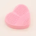 Dettaglio tappetino pulisci pennelli trucco in silicone rosa cuore, superficie strutturata. - Rosa