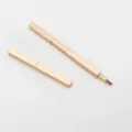 Portable retractable lip brush with a metallic gold case for precise makeup application. - Gold