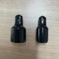 Vue détaillée des étuis de protection noirs brillants, montrant une surface lisse et un trou. - Manchon de Briquet