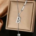 Closeup of stylish stainless steel letter B pendant necklace with geometric links on box. - Letter B Style (WY006-1-B)