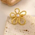 Gros plan détaillé de l'élégante broche fleur dorée avec un accent de perle centrale. - Style Perle Fleur Unique (RT215XZ)