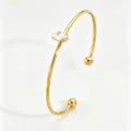 Gold stainless steel open cuff bracelet featuring a sparkling marquise zircon and ball ends. - Gold Marquise Open Bangle (RT235SZ)