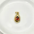 Detail shot of a teardrop metal pendant featuring a vibrant red gemstone center, elegant jewelry. - Pendant Only (Without Chain) / Red