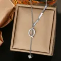 Close-up detail of the stainless steel letter Q pendant necklace on a jewelry box. - Letter Q Style (WY006-1-Q)