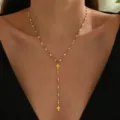 Moderna collana con croce in acciaio inox dorato con perline di smalto bianco e catena a Y chic. - Bianco