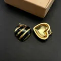 Dettaglio ravvicinato di ciondoli a cuore in smalto nero e oro per accessori di bigiotteria. - Cuore Rigato Nero (Modello D) / Ciondolo Solo (Senza Catena)