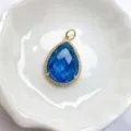 Nahaufnahme Detail des tropfenblauen Edelsteinanhängers mit funkelndem Zirkon-Heiligenschein. - Blau