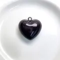Close-up detail of a glossy black heart pendant with hanging loop on white ceramic plate. - Pendant Only / Dark Coffee