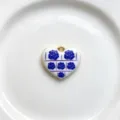Close-up detail of the heart pendant showcasing blue rose patterns and glossy gold edges. - Blue Rose Retro Style (C01-6)